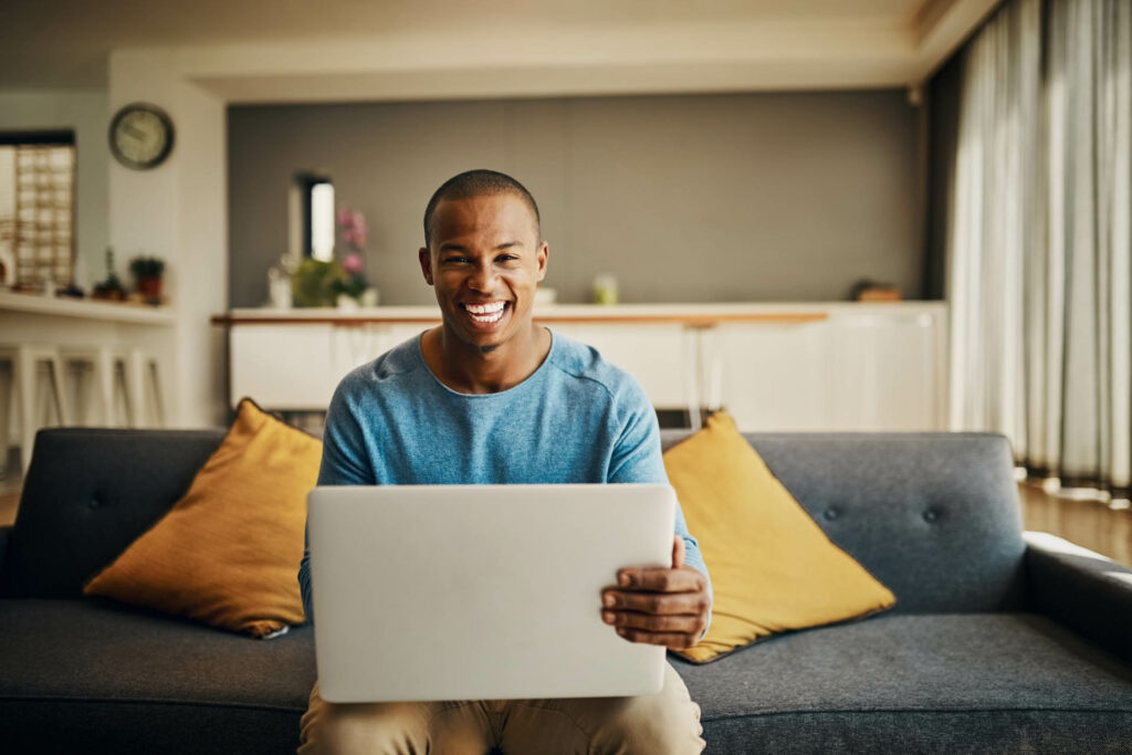 Portrait of a handsome young man using a laptop at home