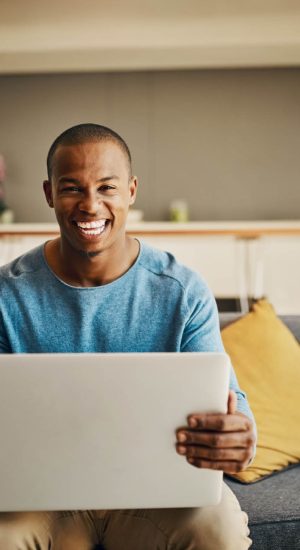 Portrait of a handsome young man using a laptop at home